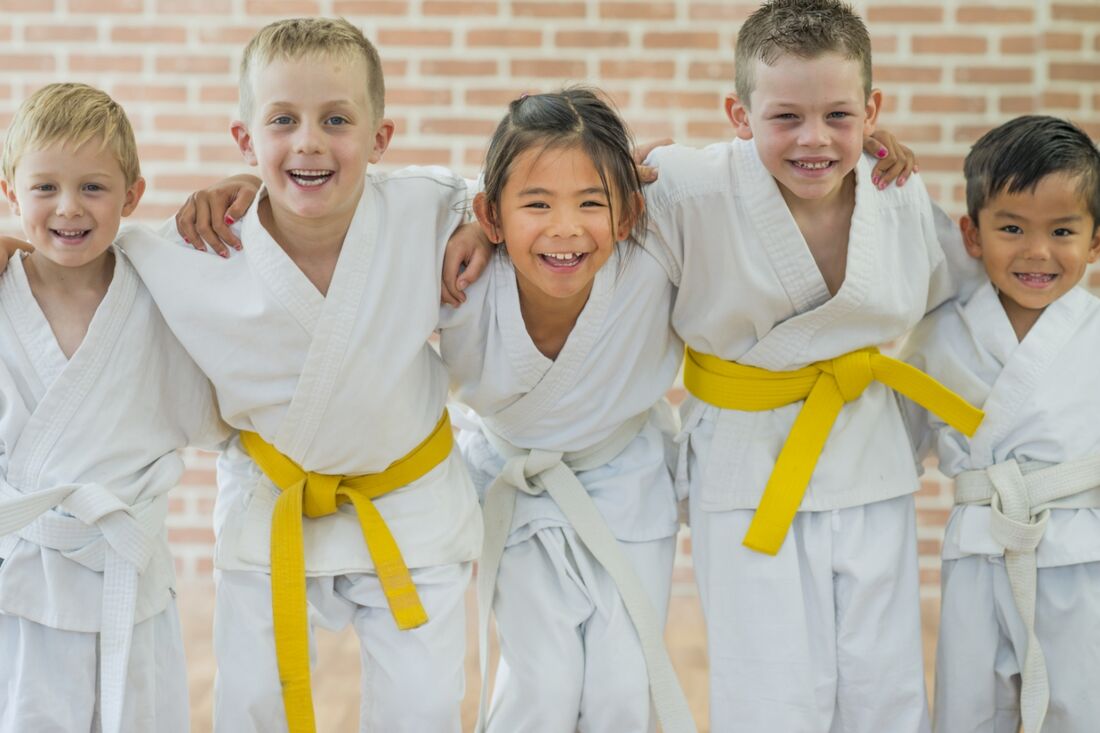 Children in Karate gear smiling