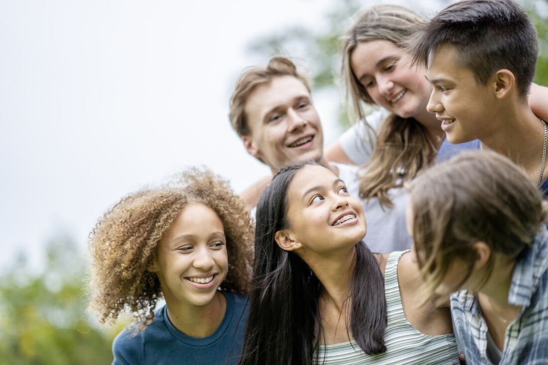 Young teens in group looking at each other