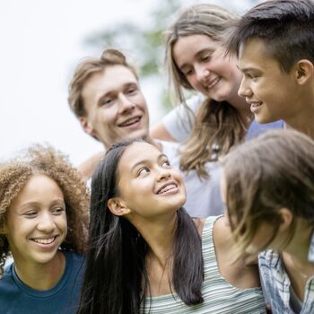 Young teens in group looking at each other